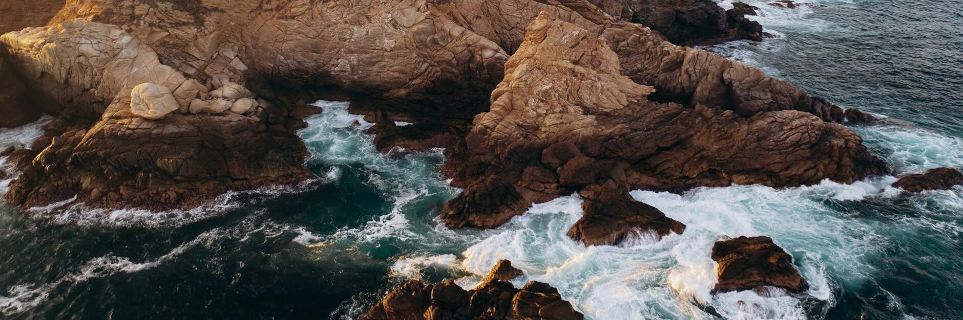 water crashing on brown rock formation